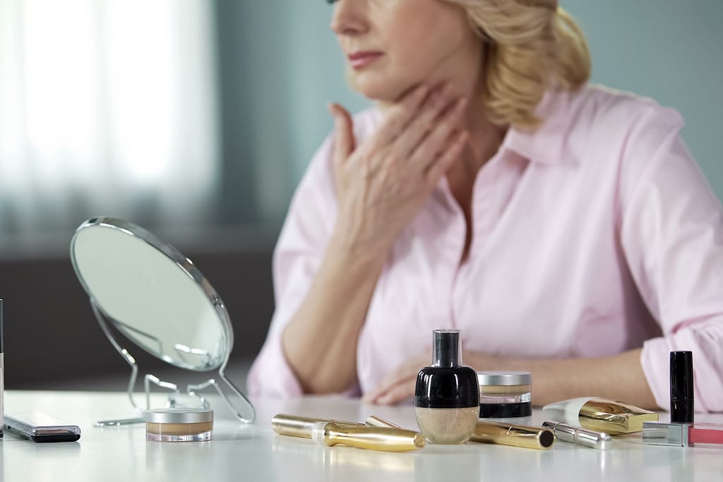Women in Midlife Crisis: Women looking in mirror at wrinkles and sagging skin